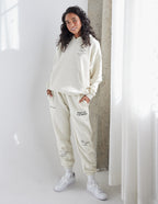 Model wearing a cream Elevated Faith Christian Hoodie with matching sweatpants for a stylish look
