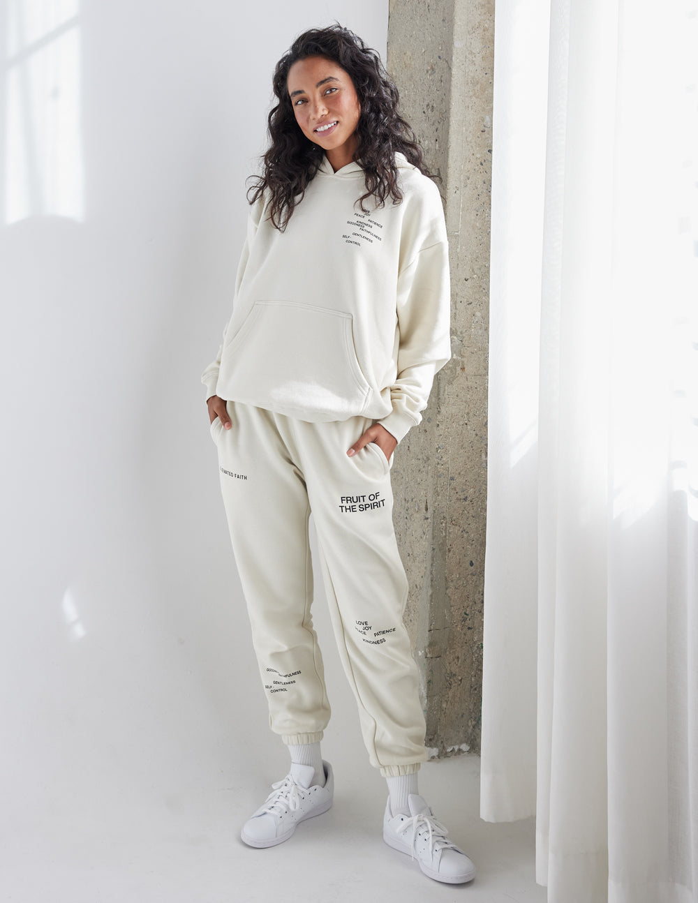 Model wearing a cream Elevated Faith Christian Hoodie with matching sweatpants for a stylish look