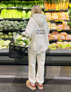 Woman wearing an Elevated Faith Christian Hoodie with 'Fruit of the Spirit' design while shopping for vegetables