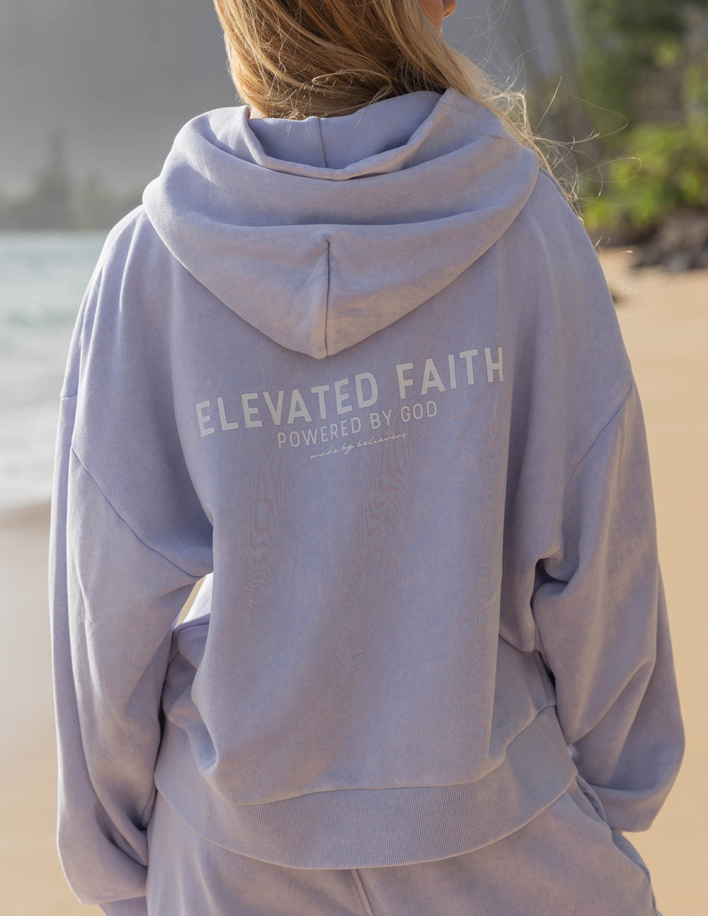 Light purple Elevated Faith Christian Hoodie featuring 'Powered by God' text on the back