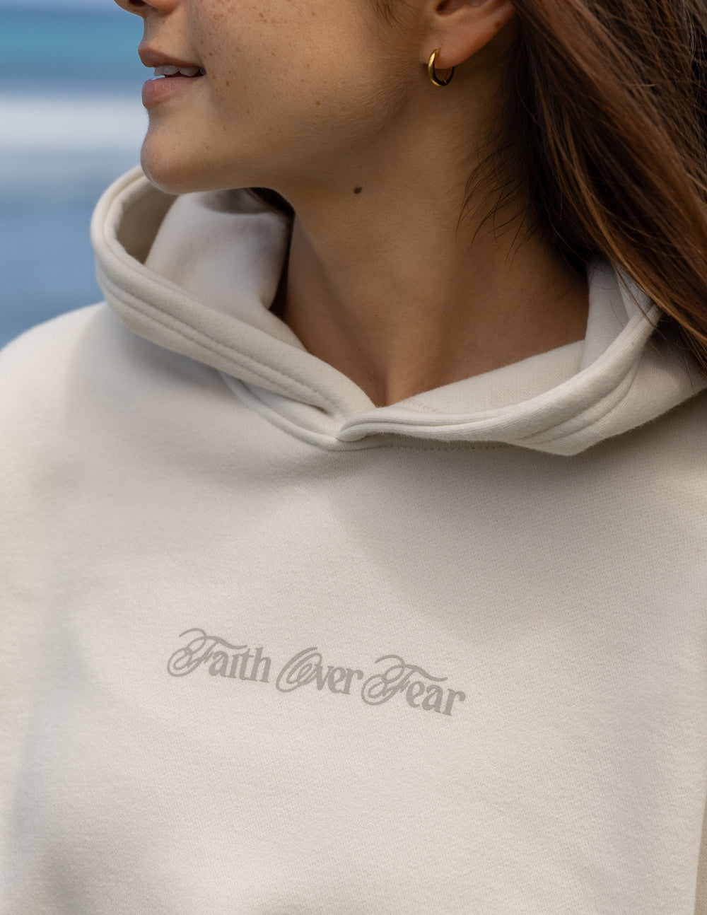 Elevated Faith Christian Hoodie in light color featuring 'Faith Over Fear' design on the chest