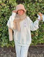 Woman wearing a cozy Elevated Faith Christian Hoodie in light color, styled with a scarf and hat