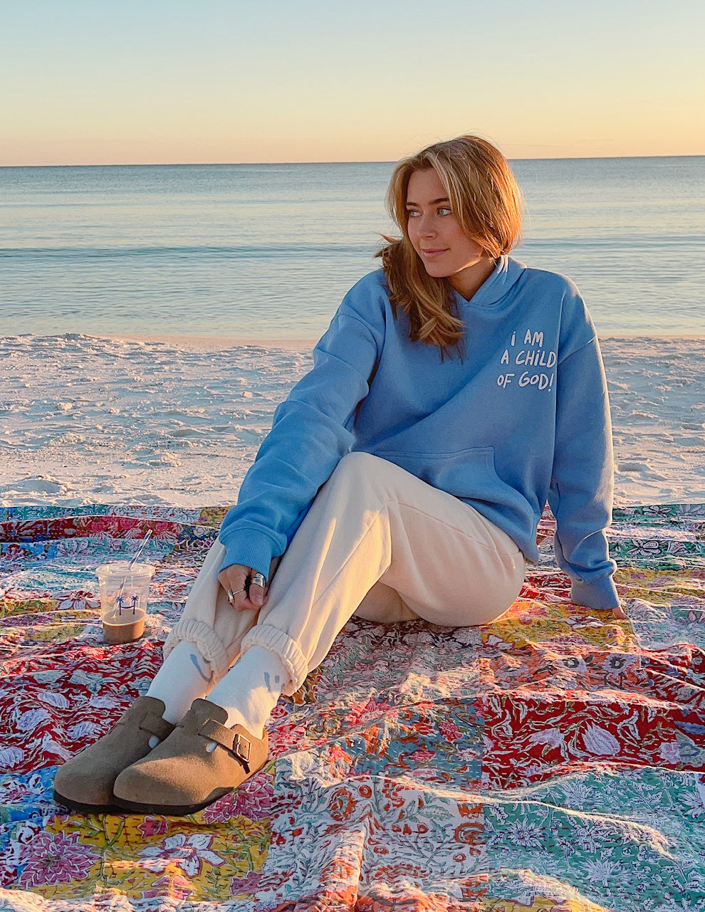 Elevated Faith Christian Hoodie in Blue with 'I Am a Child of God' Design on Beach Blanket