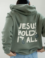 Elevated Faith Christian Hoodie in green with 'Jesus Holds It All' graphic on back