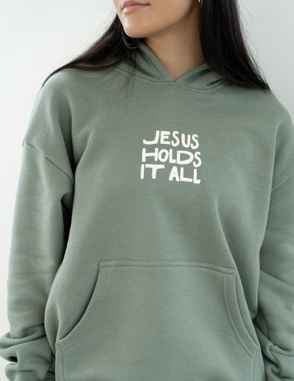 Elevated Faith Christian Hoodie in green with 'Jesus Holds It All' graphic design