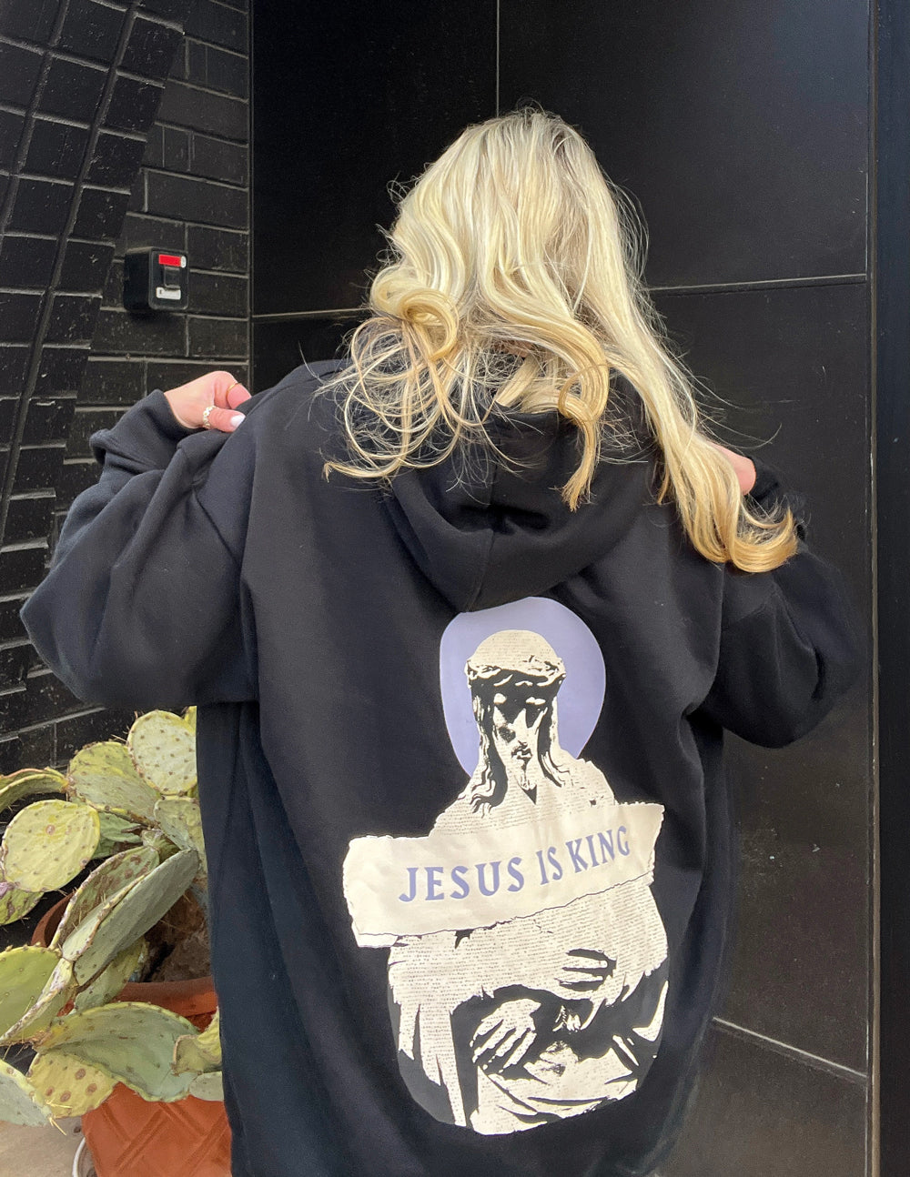 Elevated Faith Christian Hoodie in black featuring a Jesus design with 'JESUS IS KING' text on the back