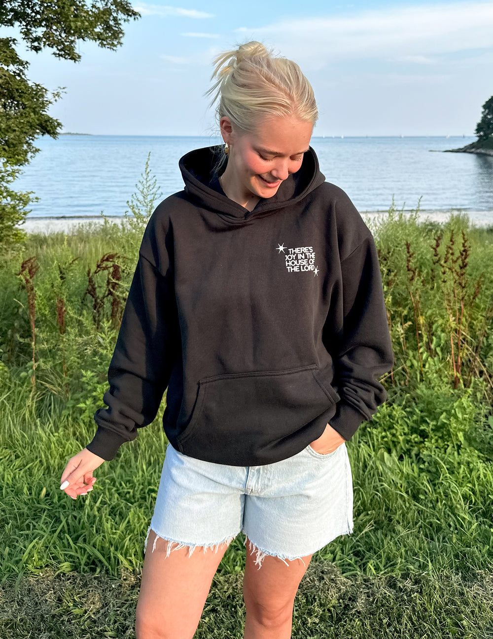 Black Elevated Faith Christian Hoodie for casual wear by the outdoor water view