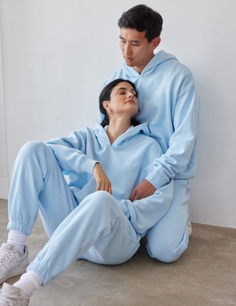 Couple wearing light blue Elevated Faith Christian Hoodie and matching sweatpants, styled for comfort