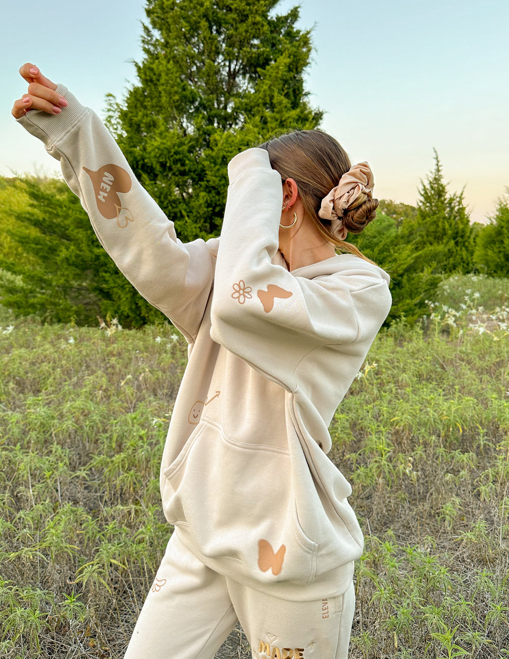 Elevated Faith Christian Hoodie in soft beige with butterfly and flower designs for stylish comfort