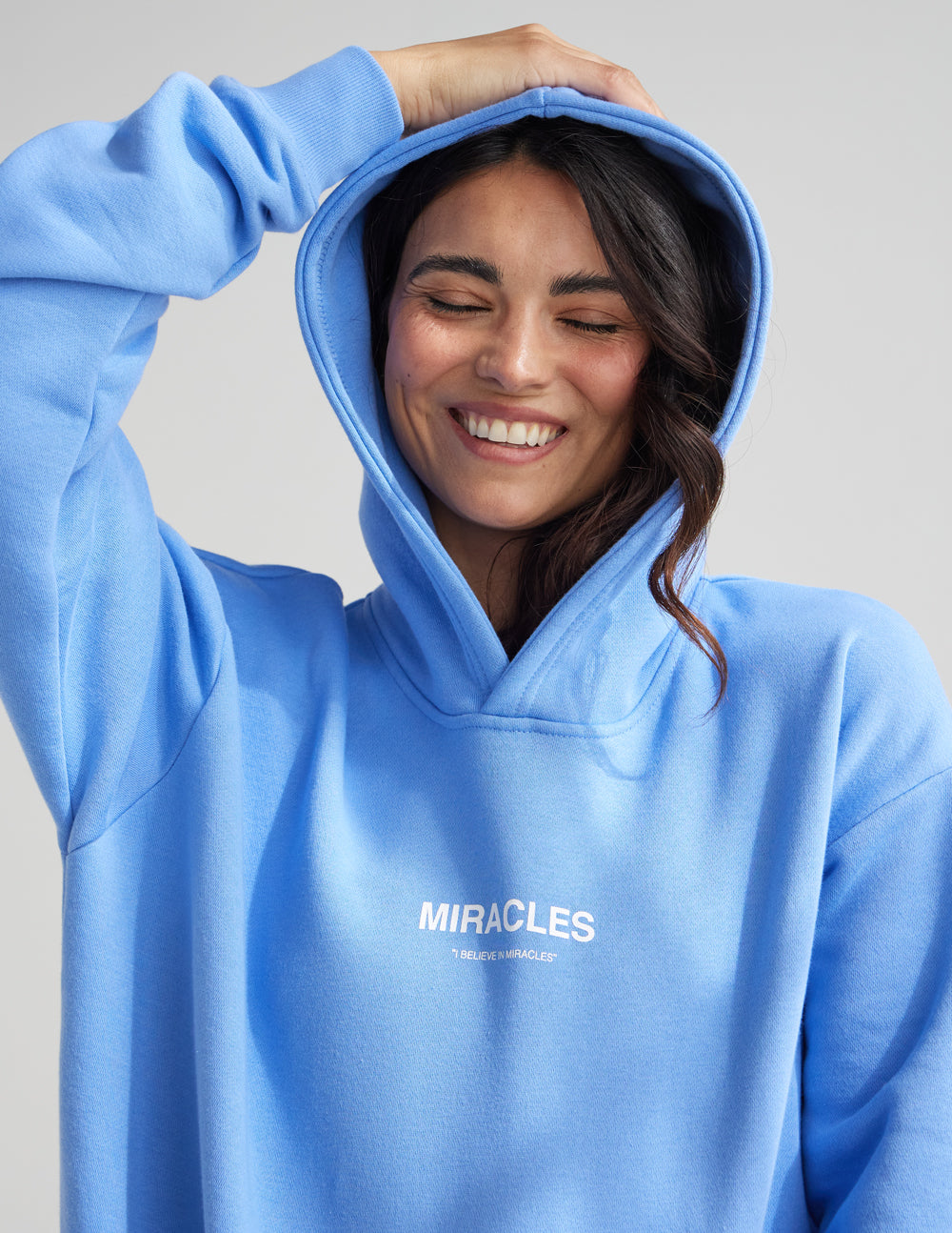 Light blue Christian Hoodie with 'Miracles' text designed for comfort and faith expression
