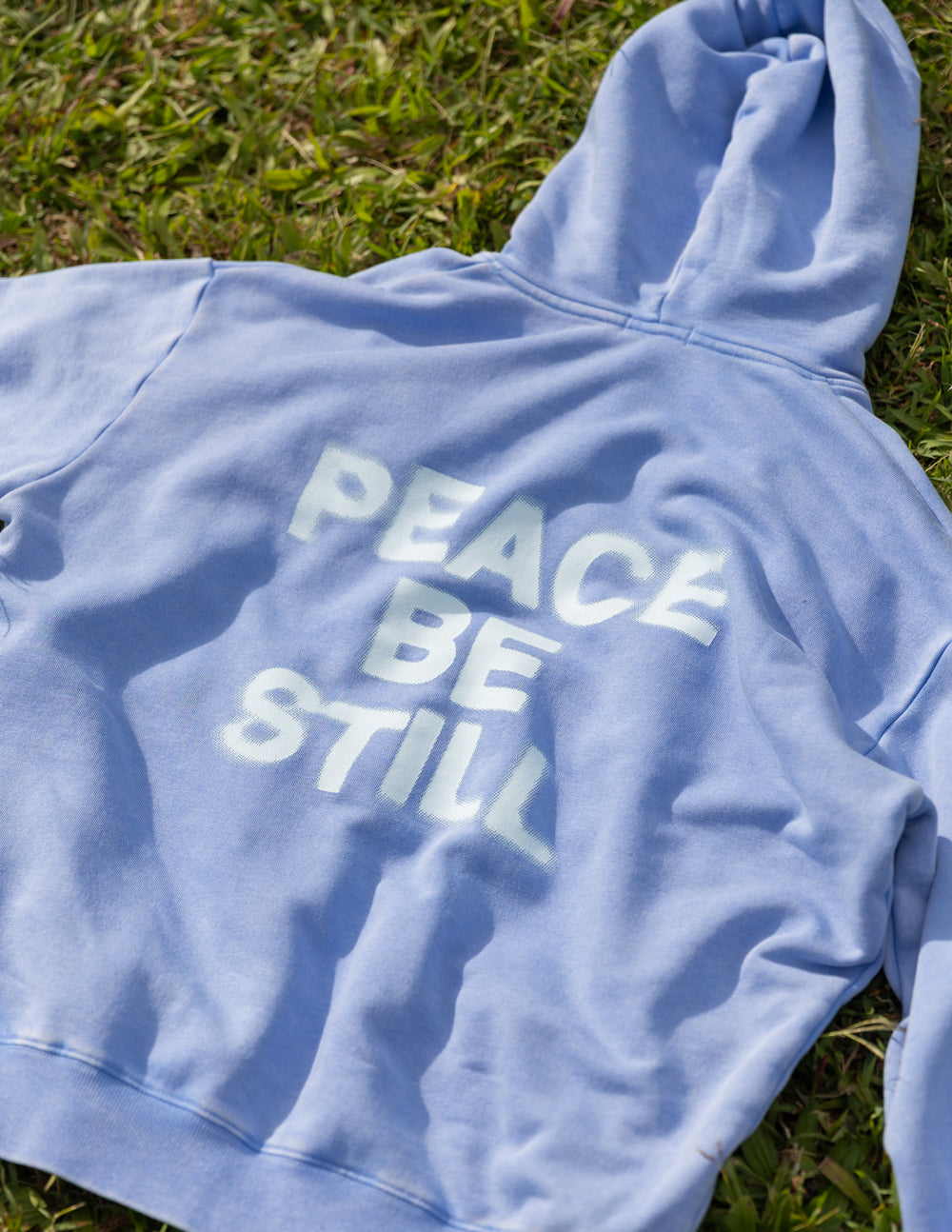 Elevated Faith Christian Hoodie in light blue with 'Peace Be Still' message on the back