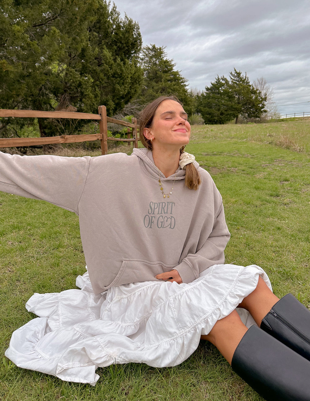Elevated Faith Christian Hoodie in beige with 'Spirit of God' print, worn in a natural outdoor setting