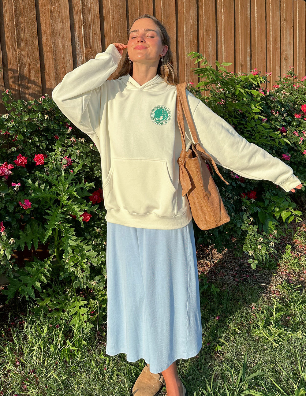 Elevated Faith Christian Hoodie in Cream with Front Graphic, Styled with a Blue Skirt and Bag