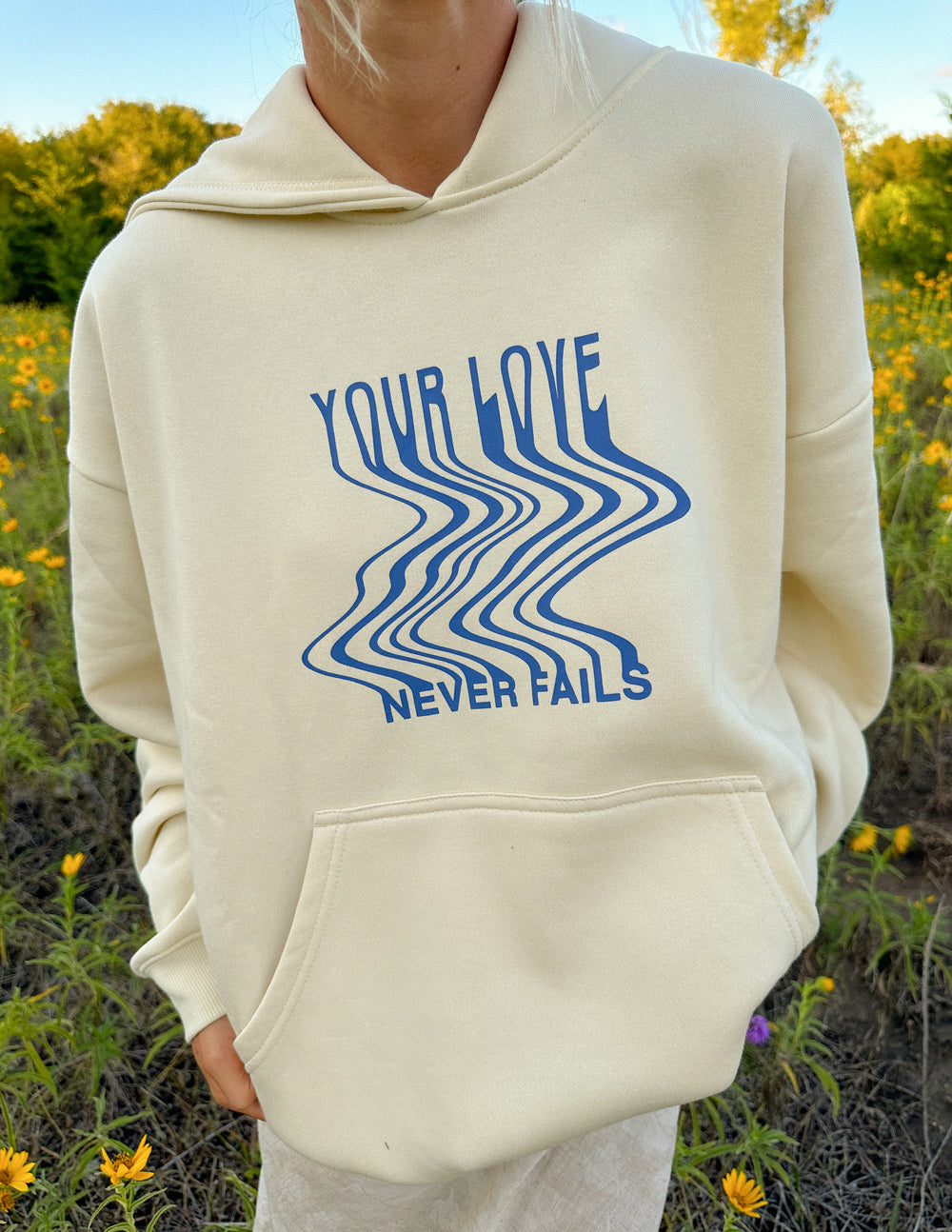 Elevated Faith Christian Hoodie in Cream with Blue Text 'Your Love Never Fails' Design