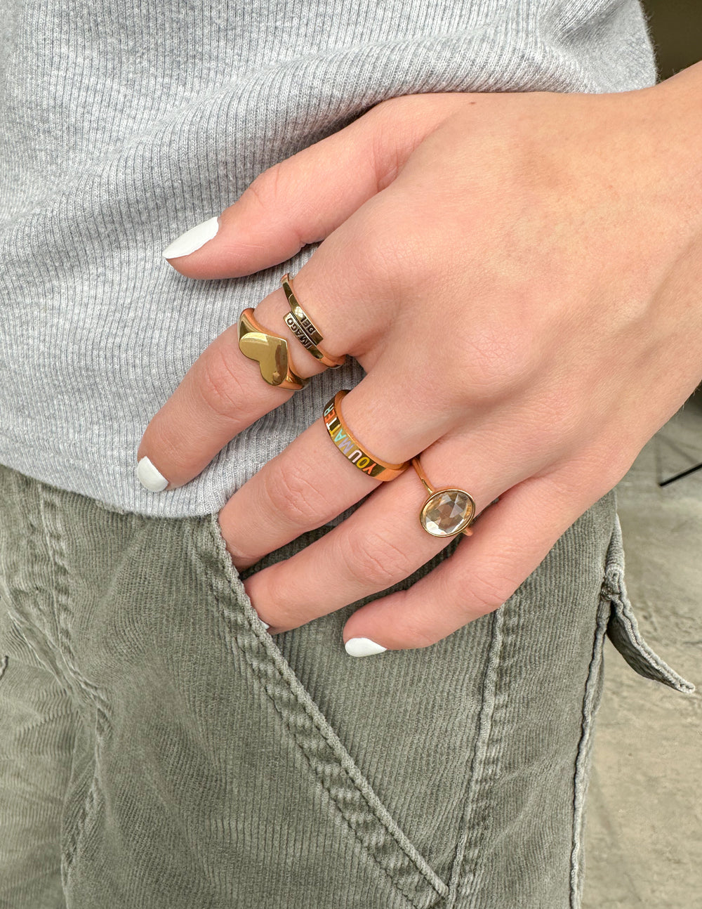 Elevated Faith Christian Jewelry rings displayed on a hand with stylish outfit details