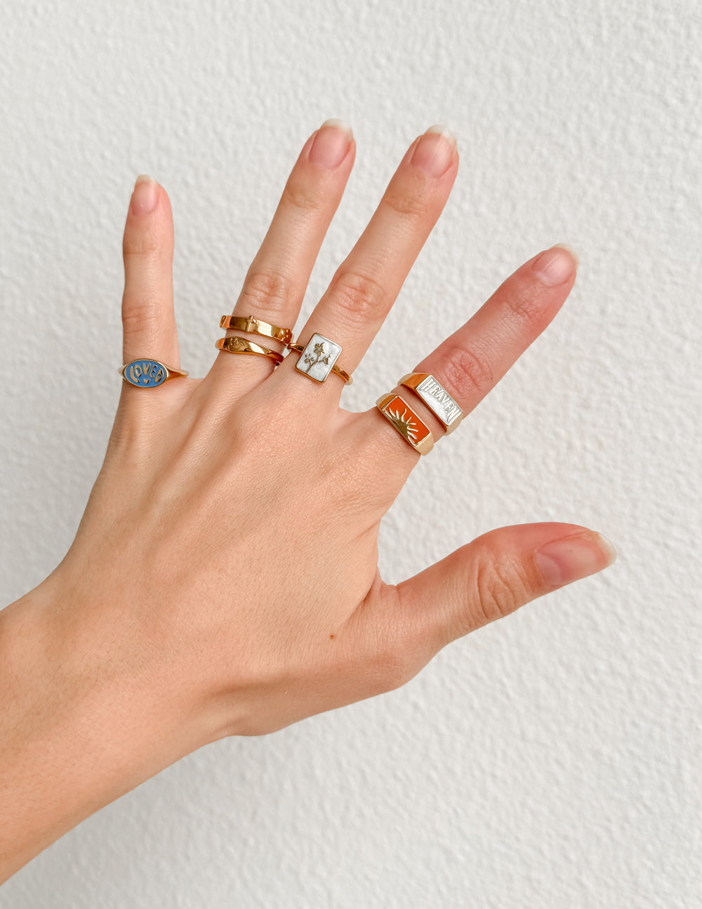 Stylish hand showcasing multiple Elevated Faith rings as unique Christian Jewelry options