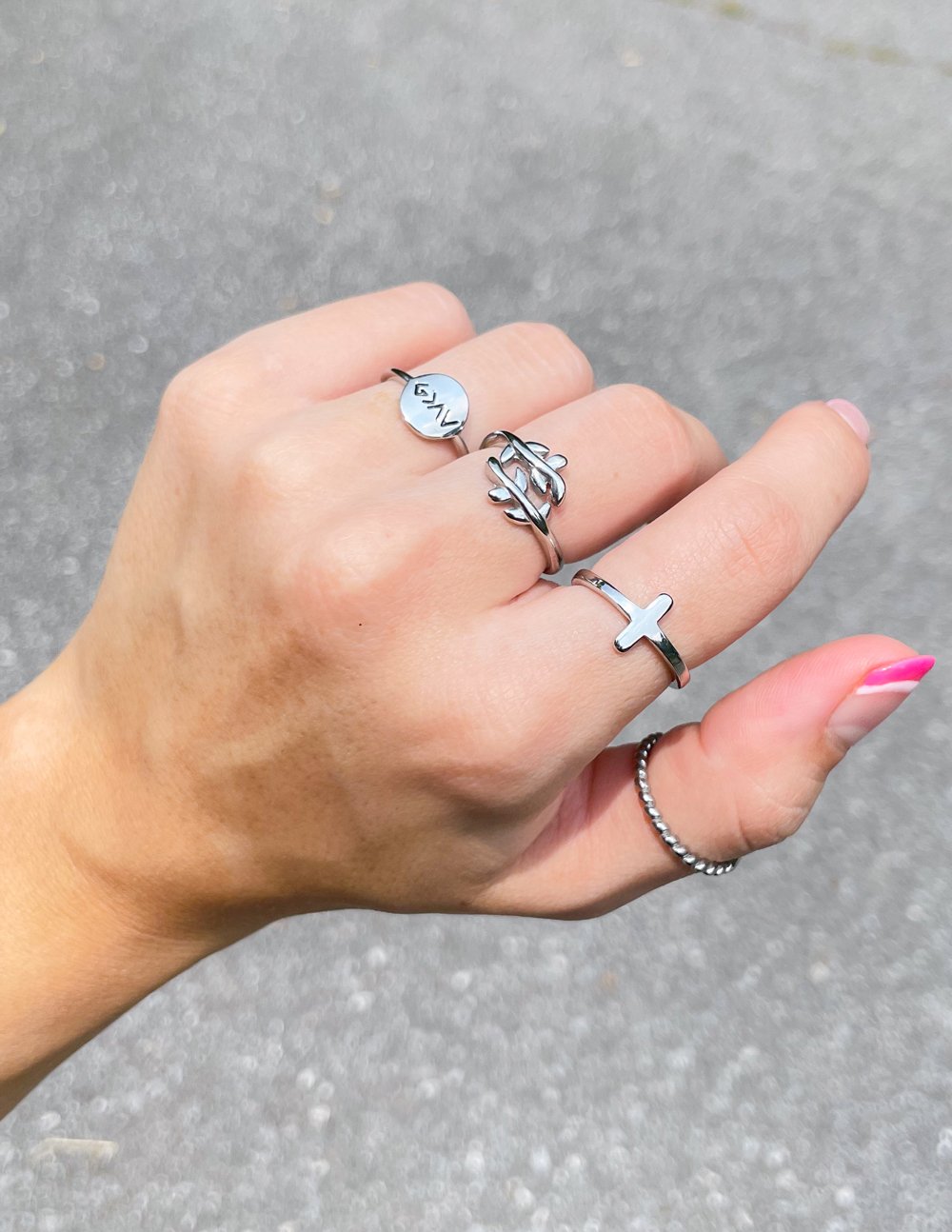 Elevated Faith Christian Jewelry collection featuring multiple stylish silver rings on a hand