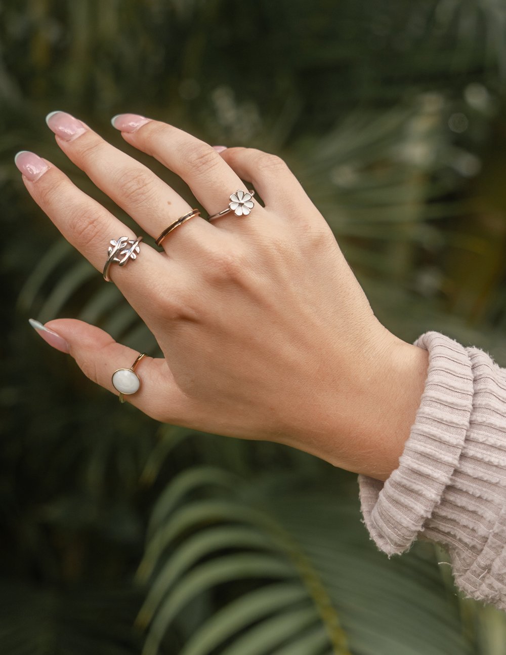 Elegant Elevated Faith ring collection showcasing delicate Christian Jewelry on a hand with a natural background