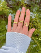 Gold Elevated Faith Christian Jewelry Rings on a Hand Against a Natural Background