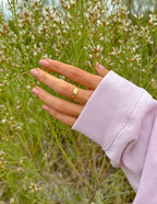 Elevated Faith Gold Ring on Finger in Nature, Showcasing Elegant Christian Jewelry Design