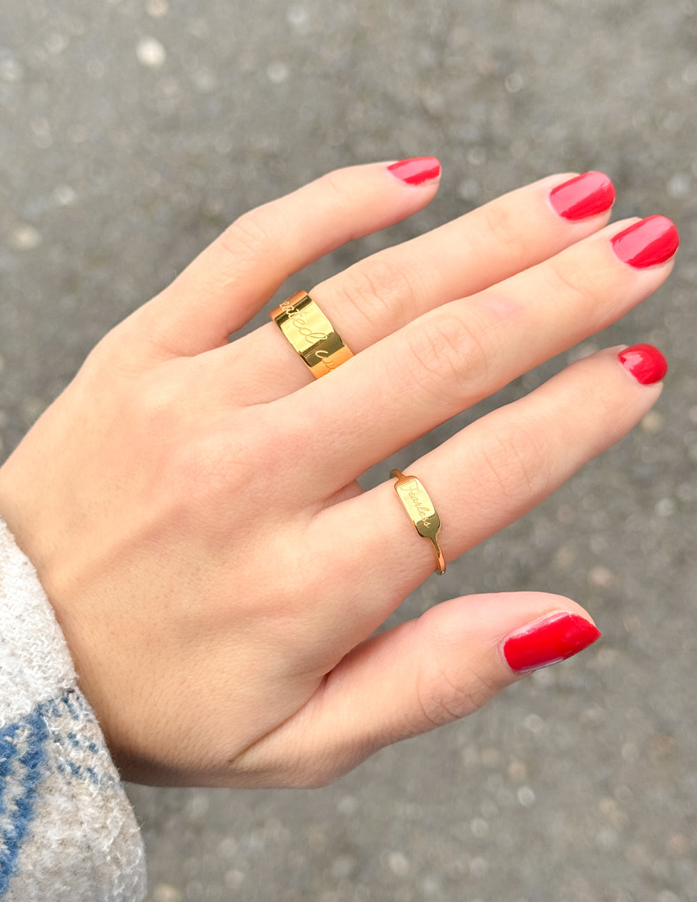 Elegant gold ring set on a hand with red nails, perfect Christian Jewelry for everyday wear