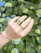 Elevated Faith Christian Jewelry Ring with Colorful Love Design on a Hand Surrounded by Greenery