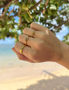 Stylish Elevated Faith Christian Jewelry rings worn on a hand by the beach