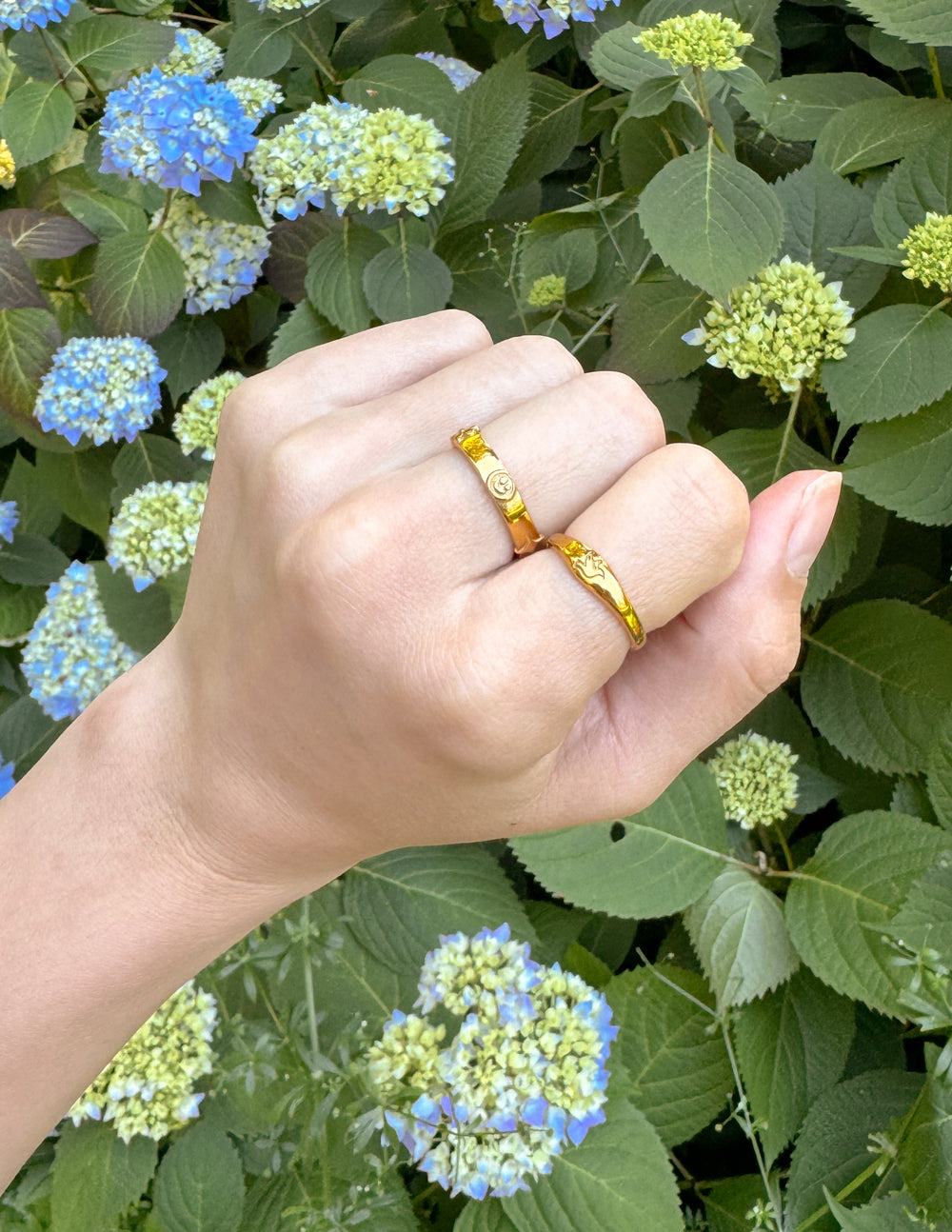 Gold Elevated Faith Christian Jewelry Rings Set on Hand Surrounded by Flowers
