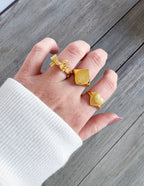 Three gold rings displayed on a hand, featuring unique designs perfect for Christian Jewelry lovers