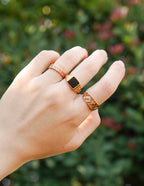 Elegant Elevated Faith Christian Jewelry rings showcased on a hand against a blurred floral background