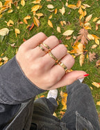 Stylish Elevated Faith Christian Jewelry rings on hand, surrounded by autumn leaves