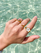 Elevated Faith Christian Jewelry featuring colorful, playful rings on a hand by the water