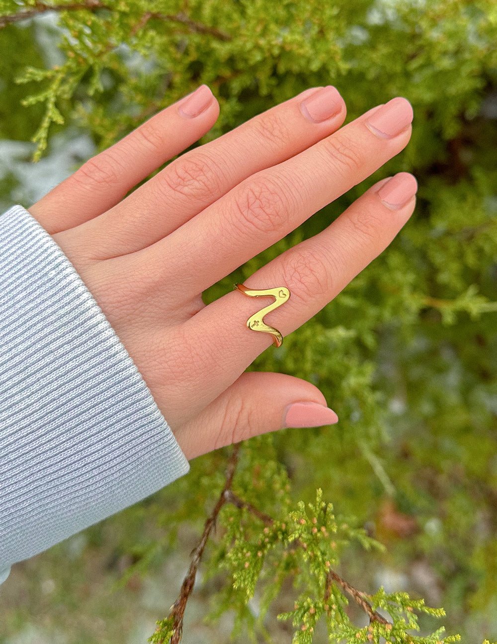 Gold wave ring showcased on a hand, part of Elevated Faith's Christian Jewelry collection
