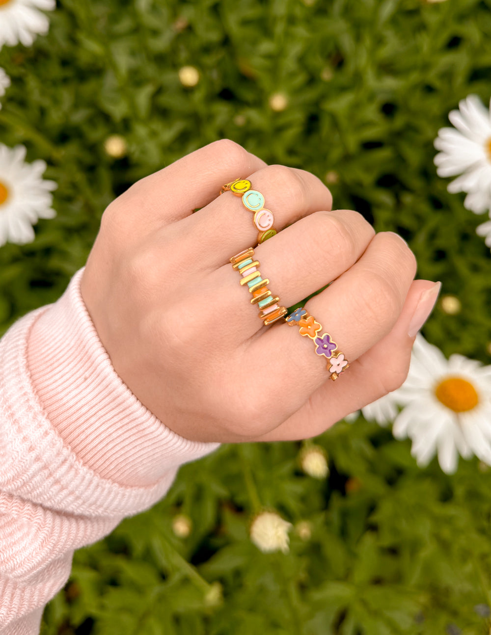 Various colorful rings displayed on a hand, highlighting elevated Christian Jewelry for fashionable faith expressions