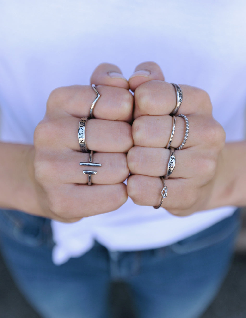 Collection of Elevated Faith Christian Jewelry rings displayed on hands with various designs and styles