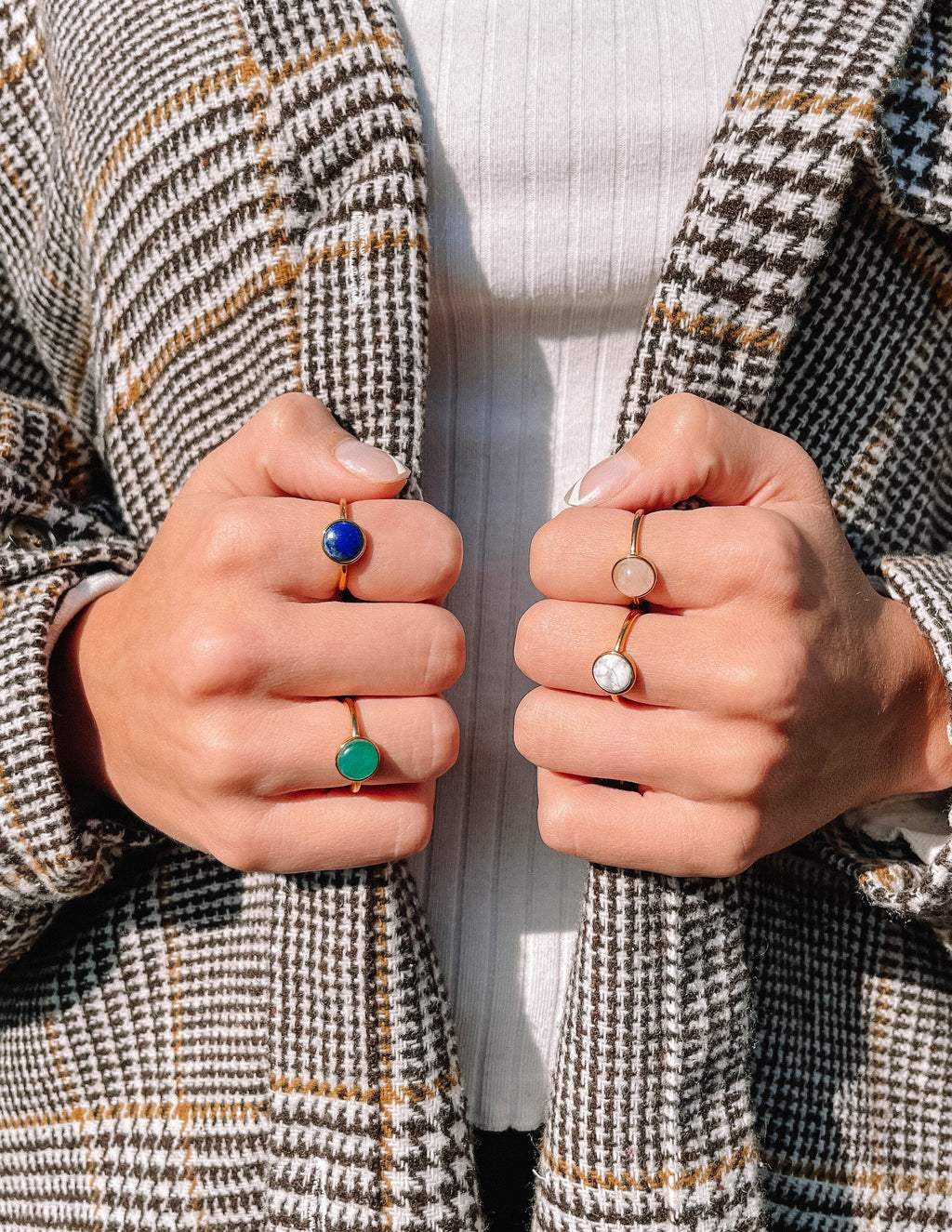 Elevated Faith Christian Jewelry featuring colorful gemstone rings on a person's fingers