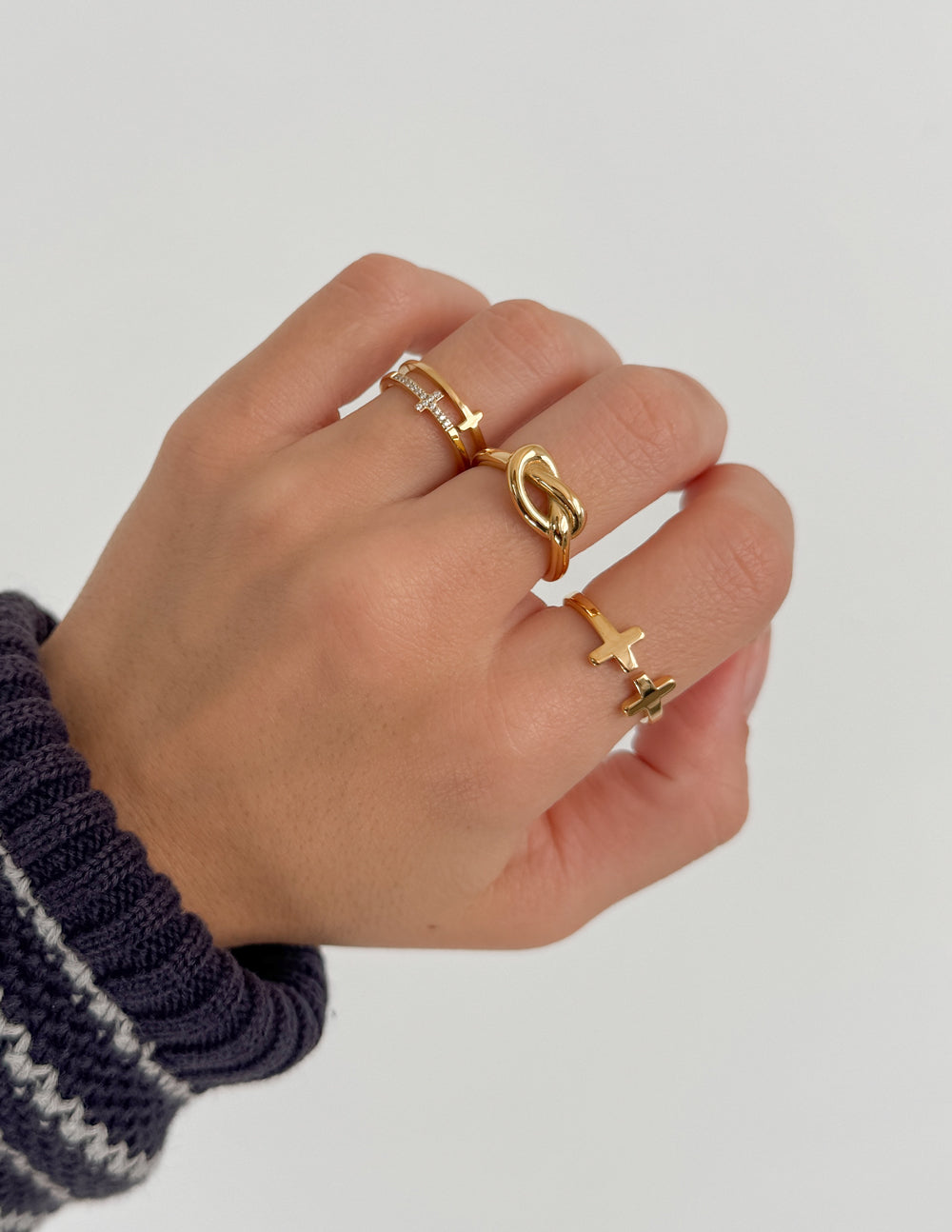Hand adorned with Elevated Faith Christian Jewelry rings, featuring cross and link designs