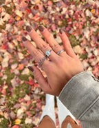 Elegant Elevated Faith Christian Jewelry rings showcased on a hand among colorful autumn leaves