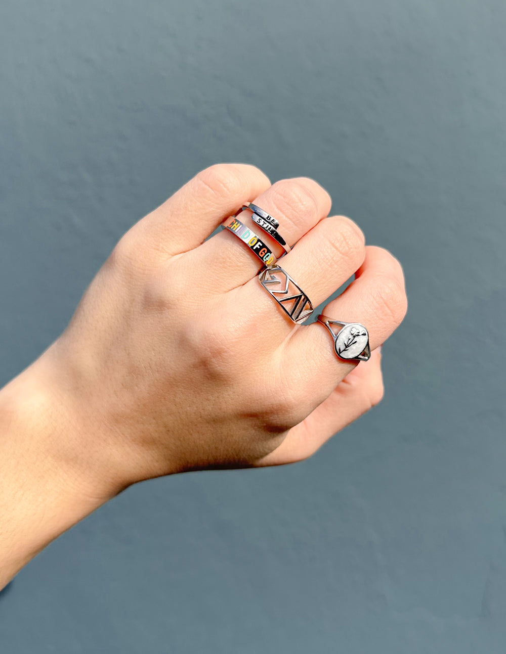 Stack of Elevated Faith Christian Jewelry rings on a hand, showcasing faith-inspired designs