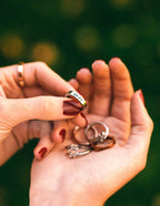 Hand holding a gold ring with the word 'GRACE', showcasing Elevated Faith Christian Jewelry collection