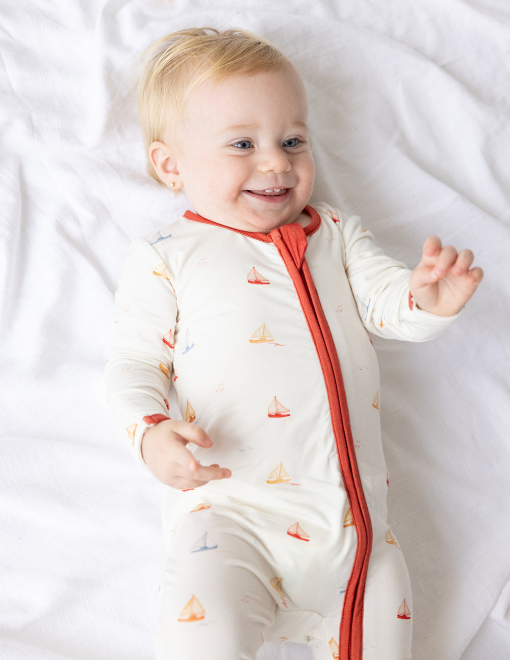 Cute baby wearing a sailboat patterned onesie from Elevated Faith, perfect for Christian Kids Apparel