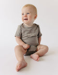 Cute baby in a gray onesie with 'Fruit of the Spirit' design from Elevated Faith, ideal Christian Kids Apparel