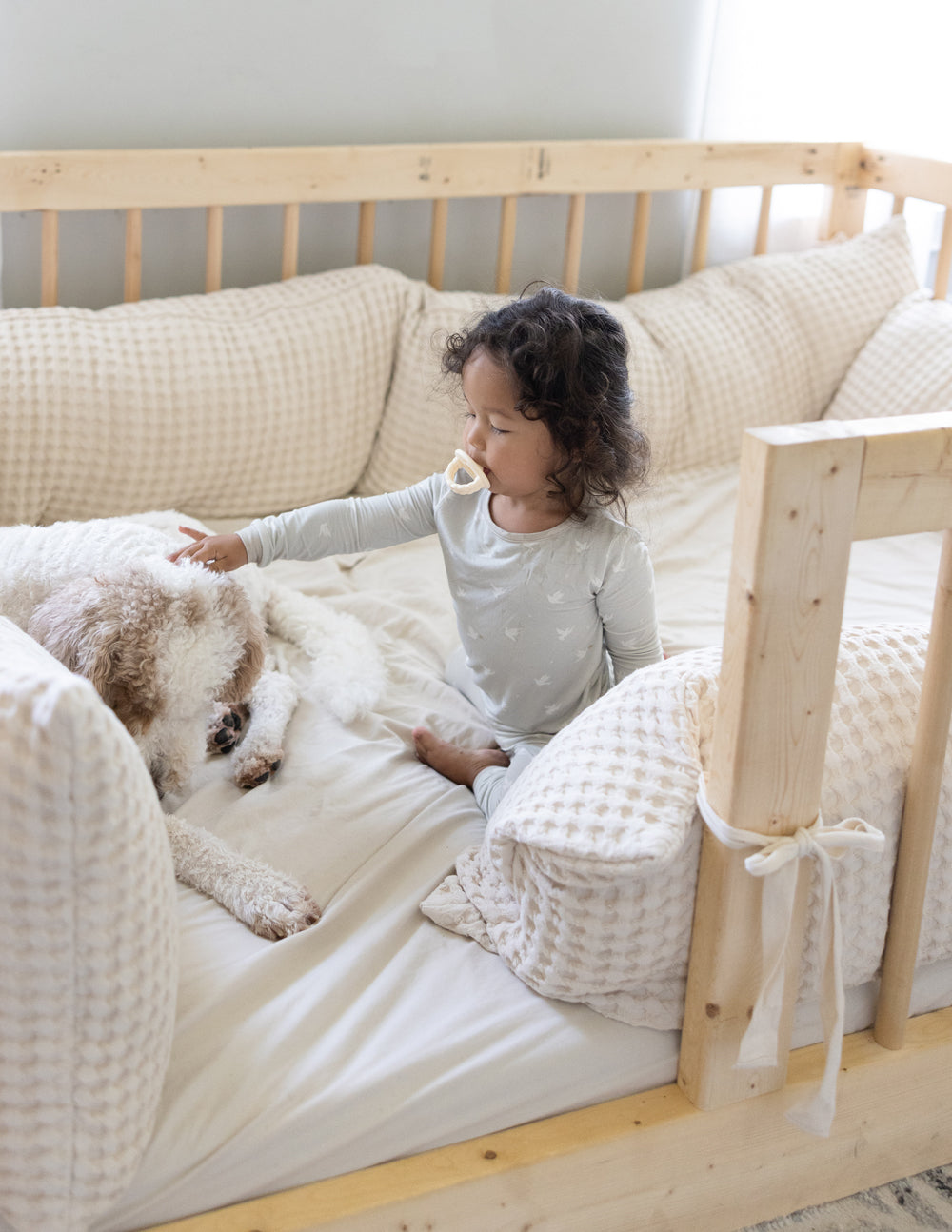 Child in Elevated Faith Kids Pajama playing with a dog, perfect for Christian Kids Apparel