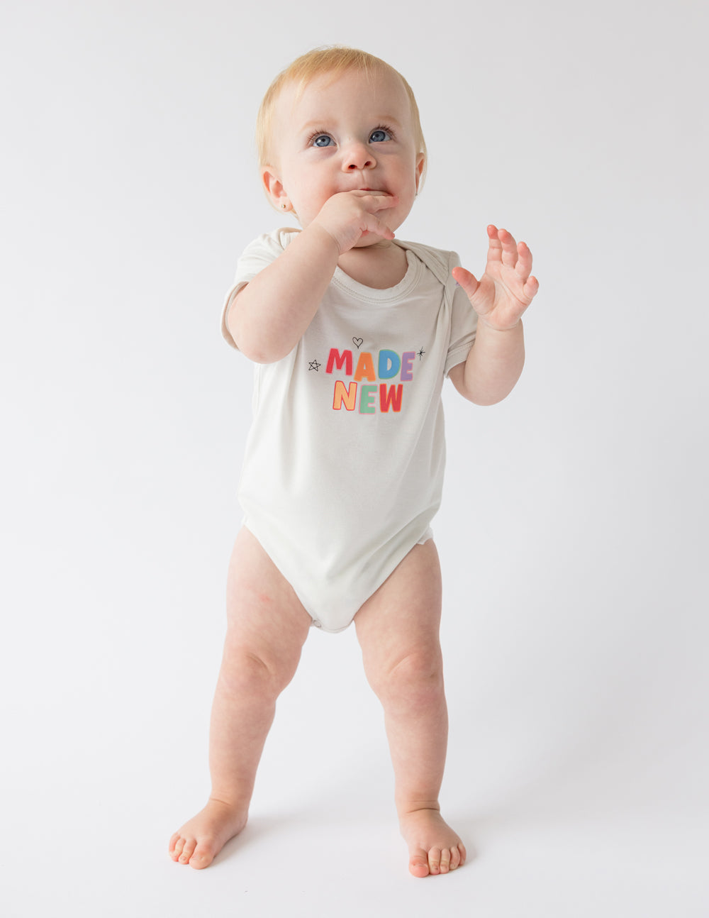 Light beige onesie for infants with colorful 'Made New' text, ideal Christian Kids Apparel