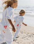 Two children wearing Elevated Faith Kids T-Shirt, perfect for Christian Kids Apparel, running on the beach