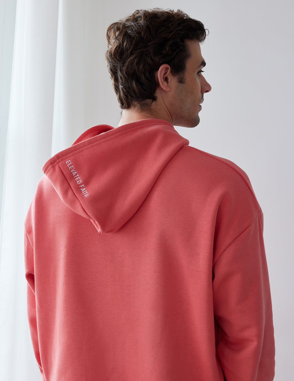 Elevated Faith Christian Hoodie in coral with a comfortable fit and logo on the hood
