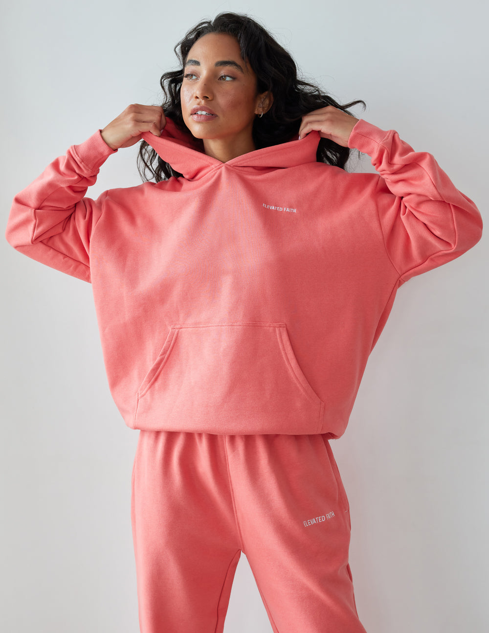 Elevated Faith Christian Hoodie in coral with front pouch pocket and relaxed fit for casual wear