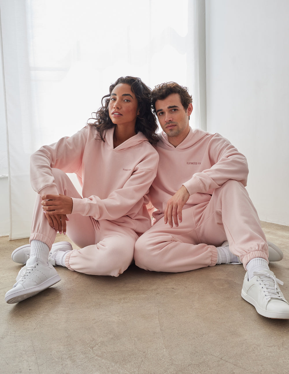 Couple wearing pink Elevated Faith Christian Hoodie for a stylish and comfortable look