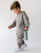 Child in Gray Elevated Faith Hoodie Holding Kids Water Bottle for Christian Kids Apparel