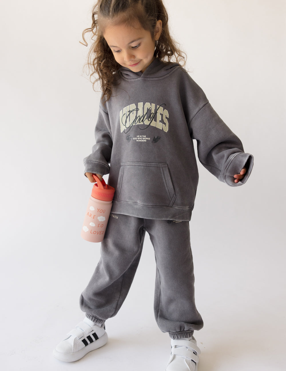 Child wearing Elevated Faith Christian Kids Apparel with a fun kids water bottle in hand